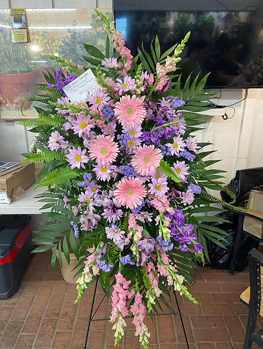 Easel spray for a funeral with pink flowers.