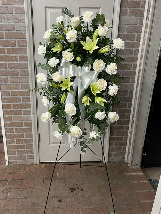 Easel spray for a funeral with white flowers.