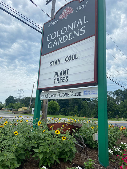 "Stay Cool - Plant Trees" on Colonial Gardens sign.